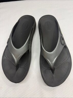Oofos unisex Black & Silver Thong Sandals
Men’s - 10. Women’s -12
